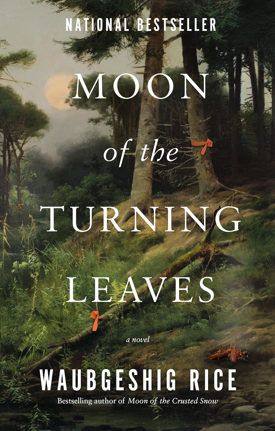 This image features the cover of "Moon of the Turning Leaves" by Waubgeshig Rice, a sequel to the bestselling novel "Moon of the Crusted Snow". The cover depicts a serene forest scene with a moonlit path leading through the trees, emphasizing the theme of journey and return.